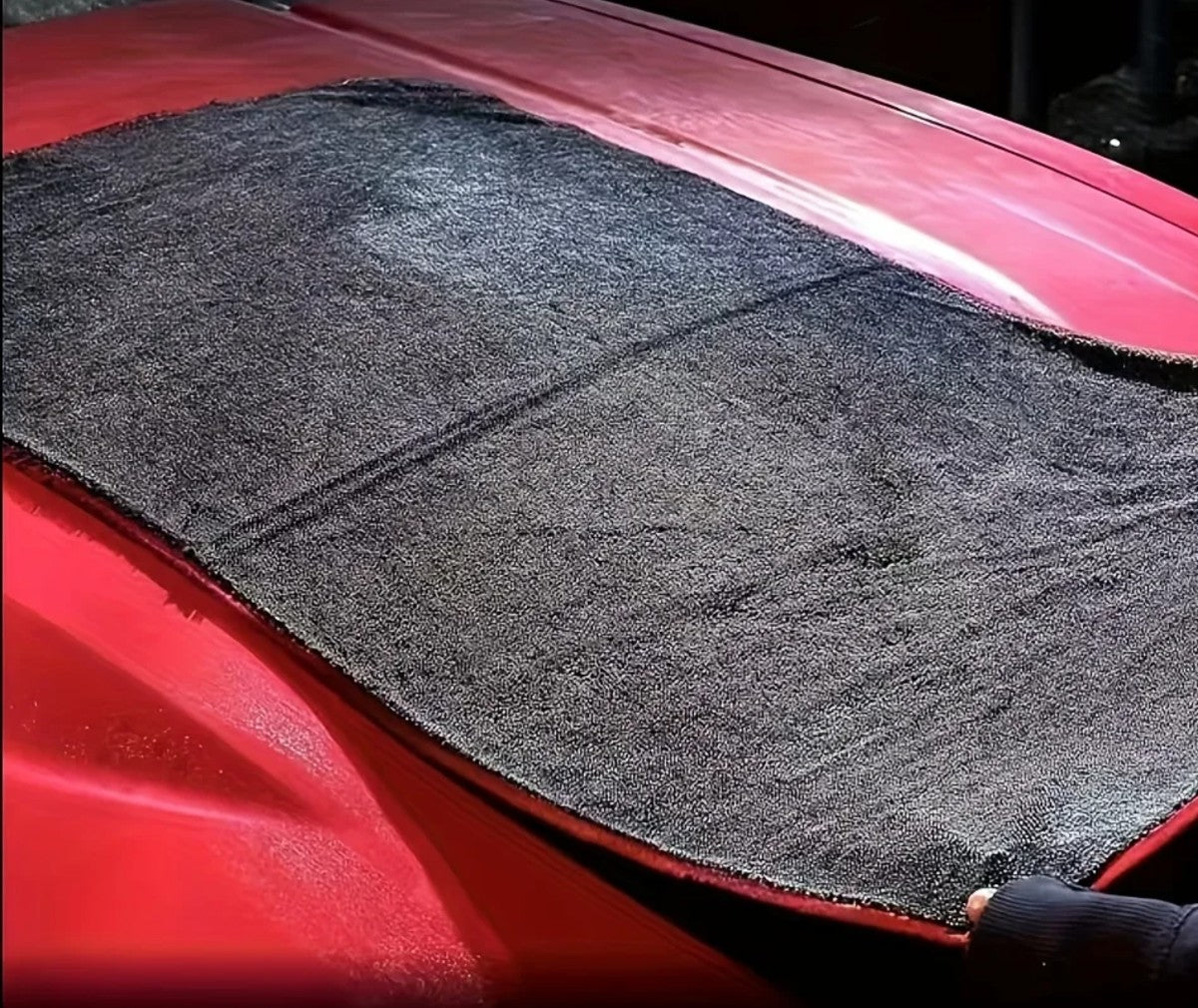 Serviette de séchage étalée à plat sur le capot d'une voiture rouge